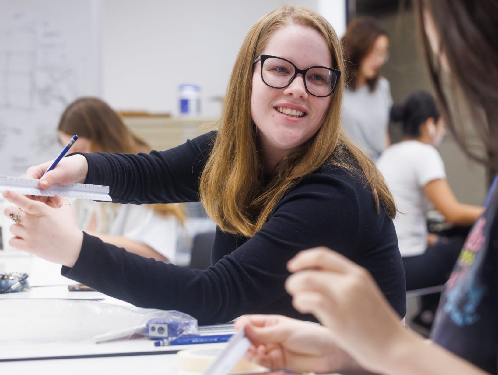 Woman talking to student in a classroom