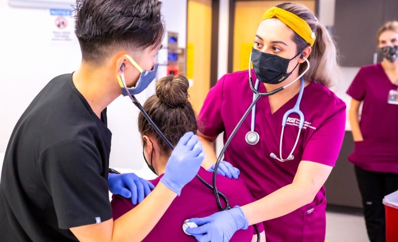 Medical students using a stethoscope