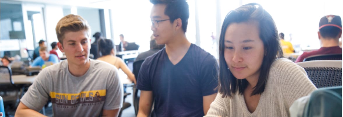 Three students working together in a classroom