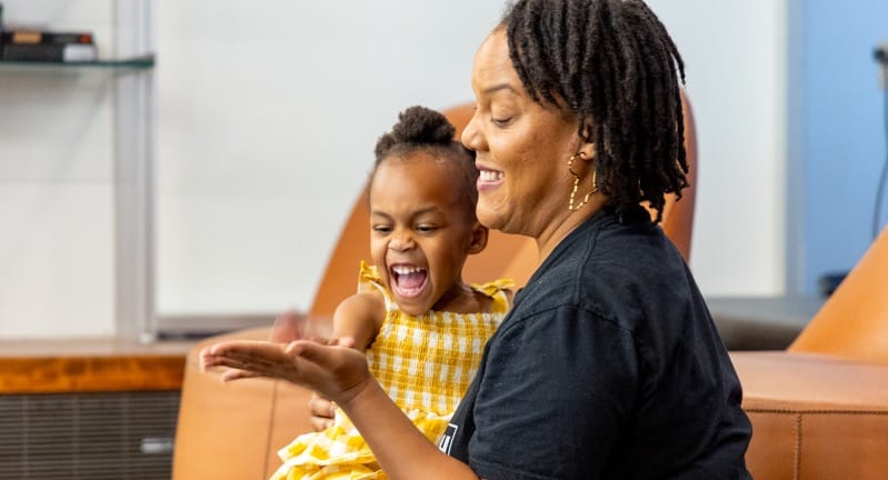 Woman and young child giving each other a high five