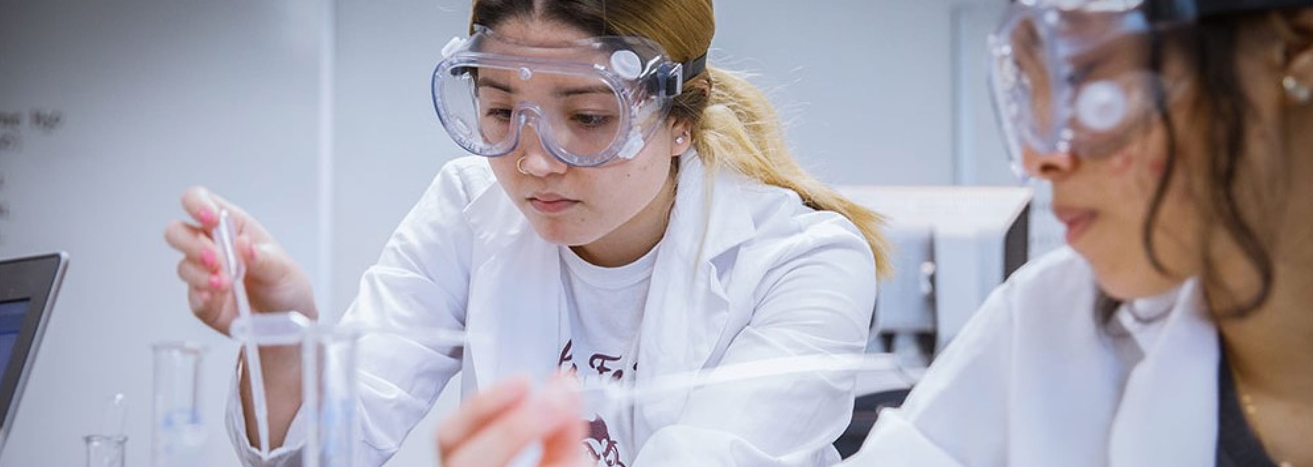 Two ASU students working in a lab with pipettes