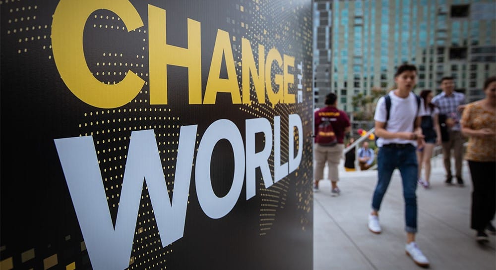 Students walking by a sign