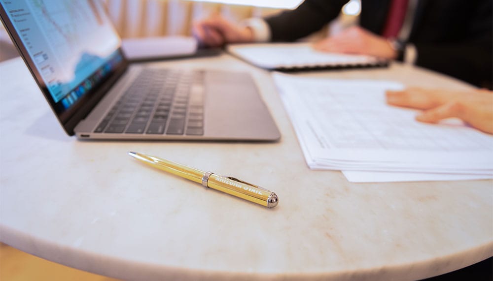 Pen, papers and laptop on desk