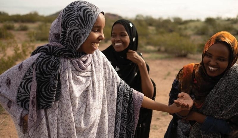 Women laughing and wearing headdresses outside