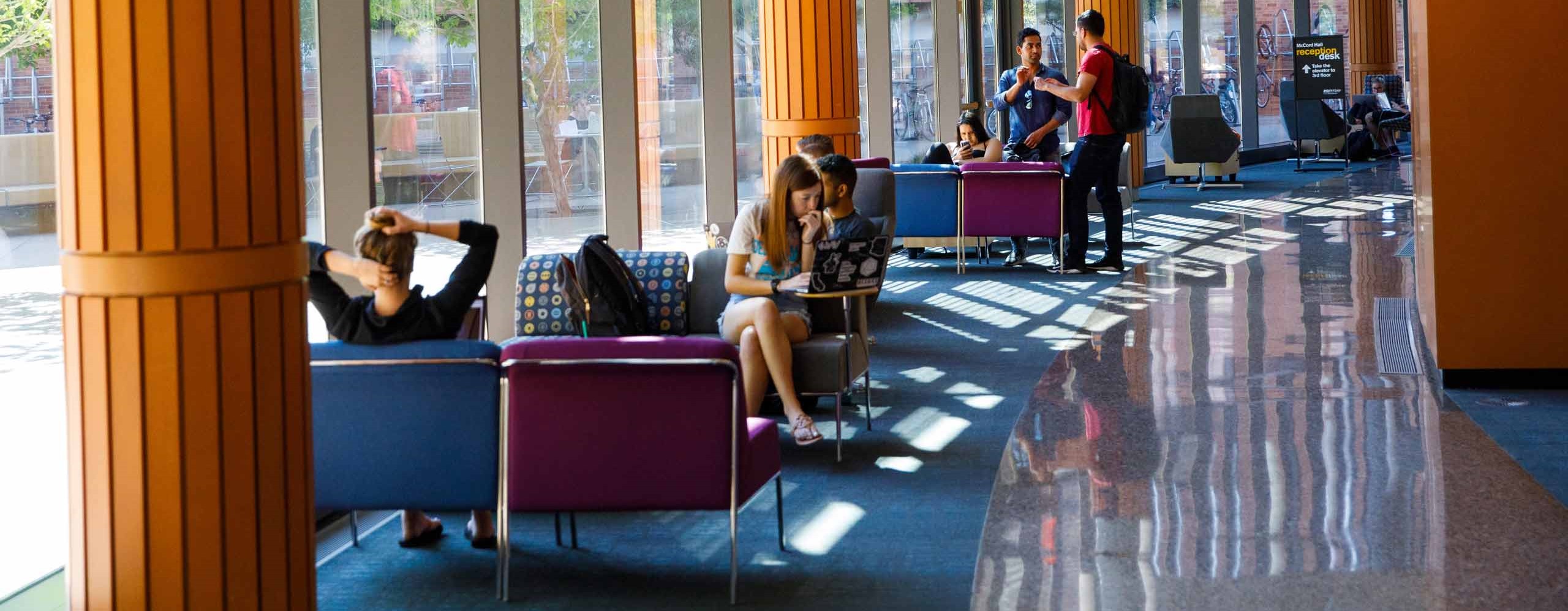 Students sitting in building lobby