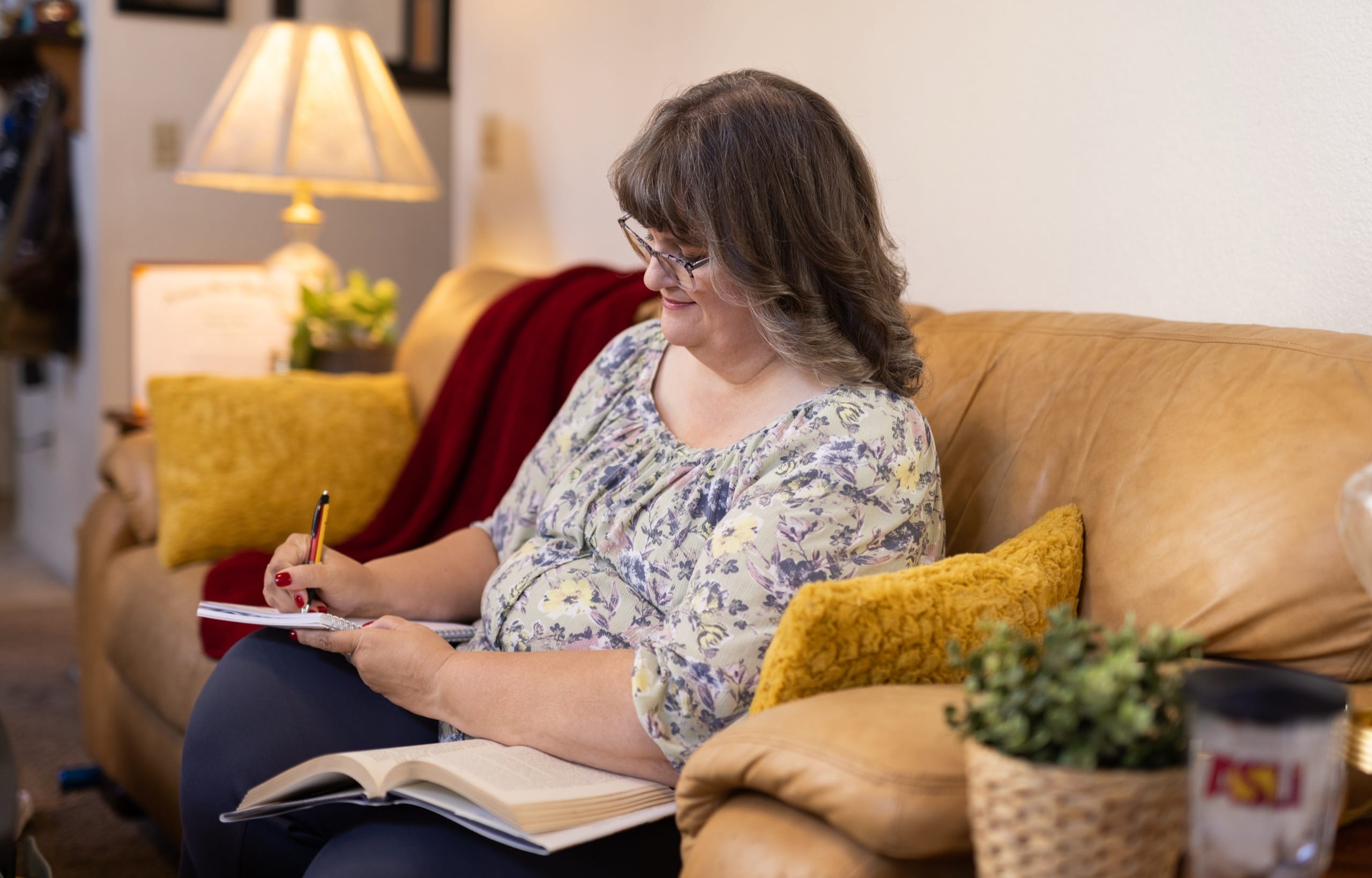 Woman sitting on a couch and writing