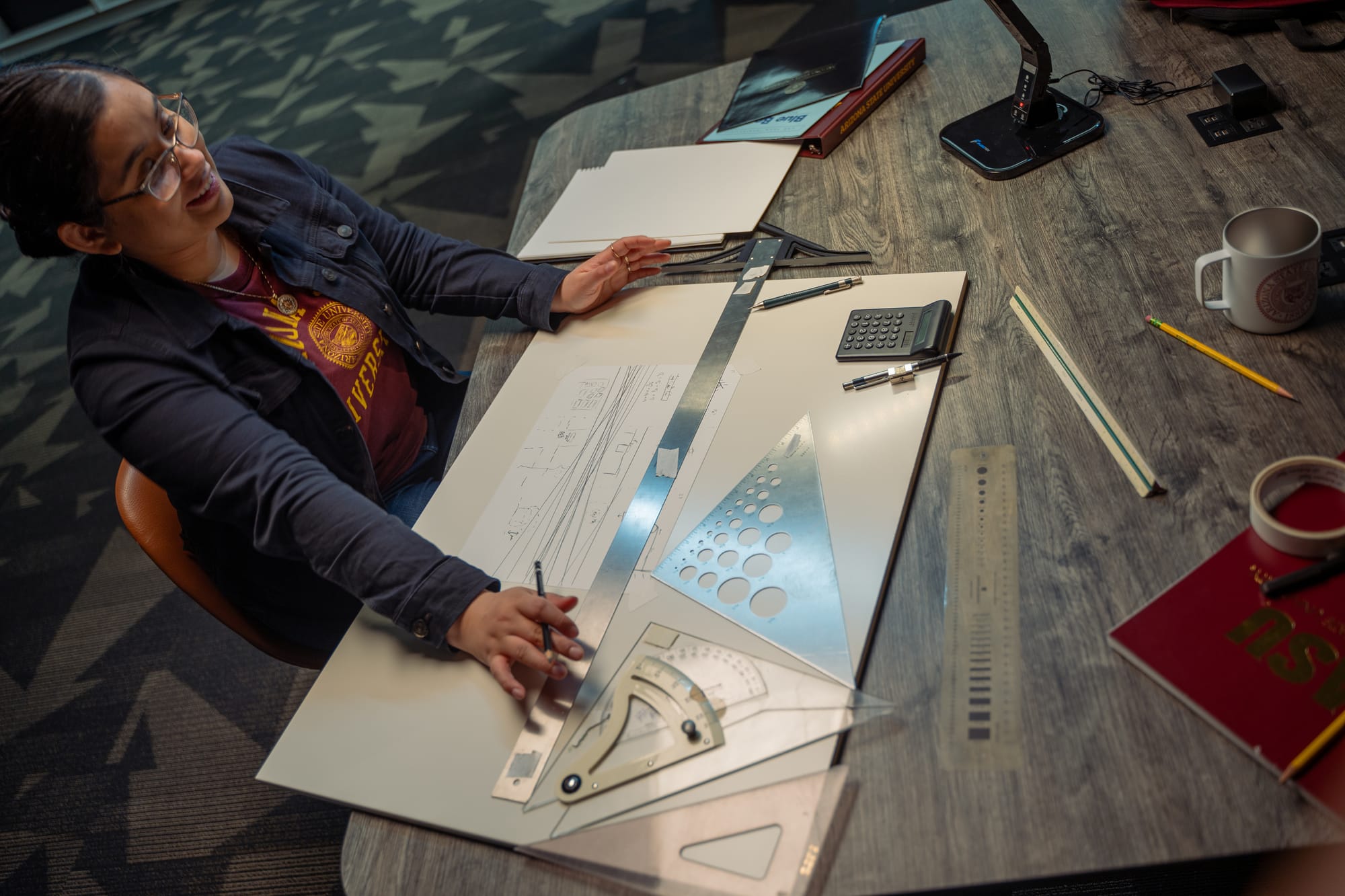 Woman working at a drafting desk