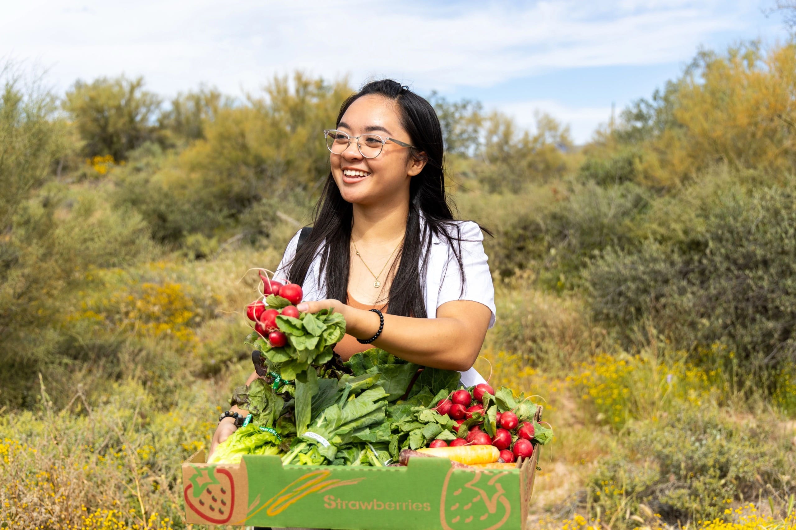 Woman with a box of fresh vegetables from the garden