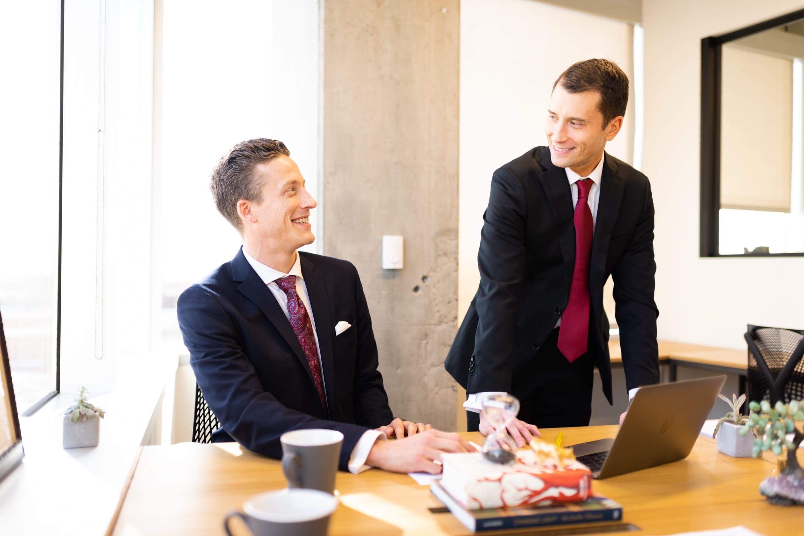 Two men smiling at a desk