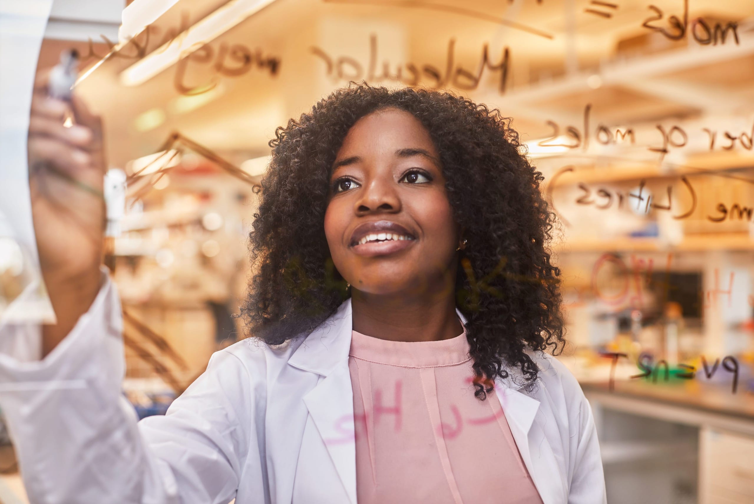 Woman working in a science lab and writing on a screen